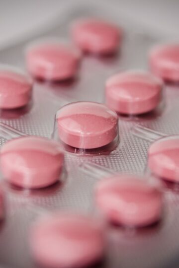 Pink tablets in a blister pack, emphasizing healthcare and medication concepts.