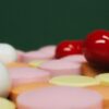 A close-up view of various colorful pills and tablets on a green background, focusing on medication variety.