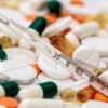 Close-up image showing various pills and a thermometer, emphasizing health and medicine.