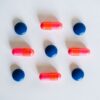 Various blue and pink pills and capsules arranged on a white background, showcasing medication.