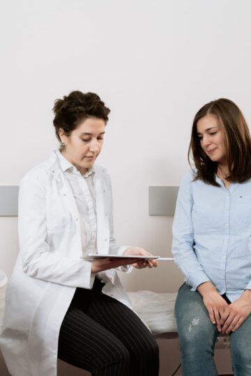 A pregnant woman consulting with a gynecologist in a medical facility.