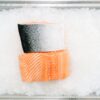Close-up of raw salmon fillets on ice showcasing freshness and quality.