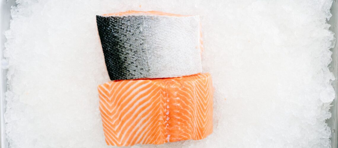 Close-up of raw salmon fillets on ice showcasing freshness and quality.