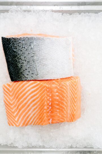 Close-up of raw salmon fillets on ice showcasing freshness and quality.