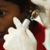 A young boy undergoes a routine ear examination by a medical professional using an otoscope.