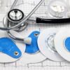 Medical instruments including stethoscope and ECG electrodes on a cardiology chart.