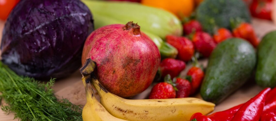 A variety of fresh fruits and vegetables arranged beautifully on a wooden table, showcasing natural nutrition.