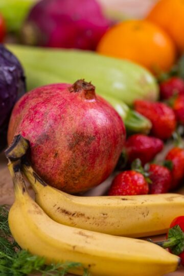 A variety of fresh fruits and vegetables arranged beautifully on a wooden table, showcasing natural nutrition.
