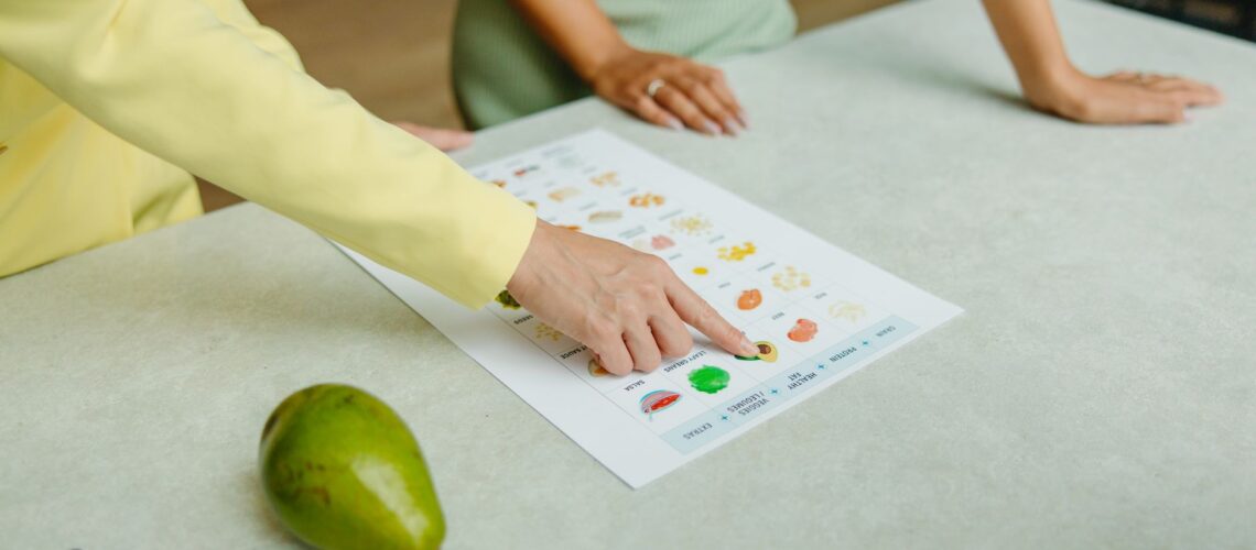 Two adults discussing food options with a chart, highlighting healthy nutrition indoors.