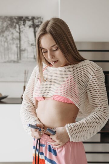 A young woman administers an insulin injection at home, highlighting diabetes care.