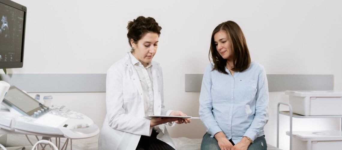A pregnant woman consulting with a gynecologist in a medical facility.