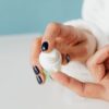 Detailed shot of hands applying skincare cream with gentle focus.