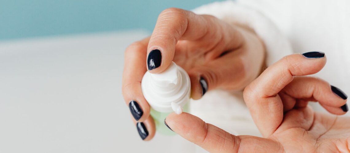 Detailed shot of hands applying skincare cream with gentle focus.