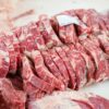 A close-up shot of sliced beef in a meat processing setting, showcasing freshness and detail.
