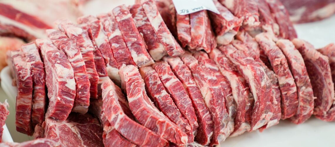 A close-up shot of sliced beef in a meat processing setting, showcasing freshness and detail.