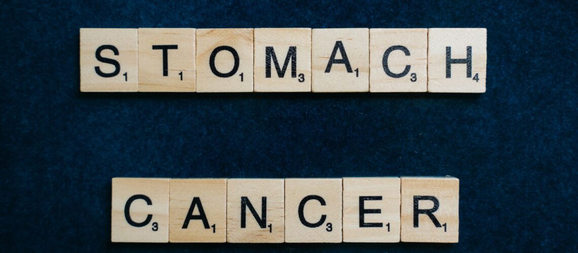 Scrabble tiles spelling 'Stomach Cancer' on a dark blue background, symbolizing awareness.