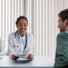 A doctor and patient engaging in a positive consultation in a bright clinic setting.