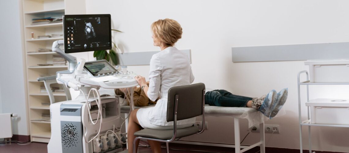 Doctor performing ultrasound scan on patient in modern clinic.