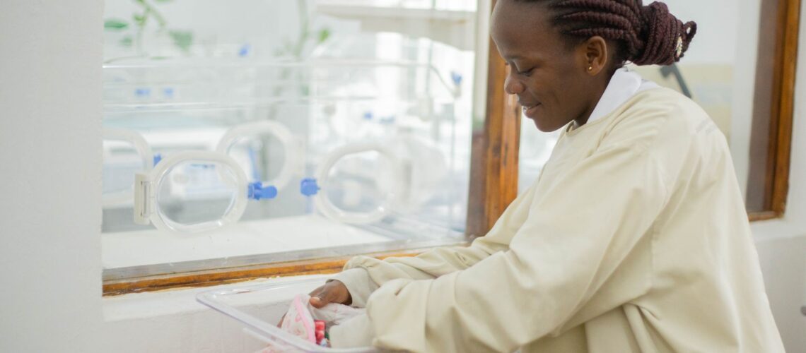 A nurse tending to a newborn in a hospital nursery, showing care and compassion.