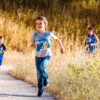 Children joyfully running in a park during a cheerful outdoor race event.