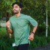 Adult male running outdoors in a lush park, embracing a healthy lifestyle.