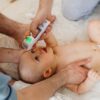 Father uses a digital thermometer to measure his baby's temperature at home.