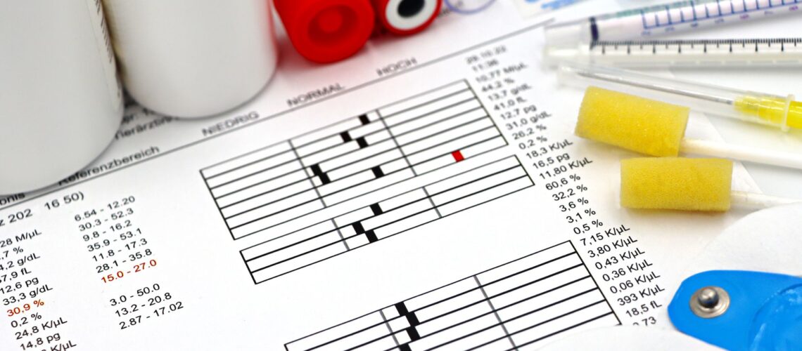 Arrangement of medical equipment, lab tests, and health data on a clinical table.
