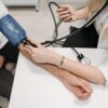 A doctor measures a patient's blood pressure with a sphygmomanometer during a consultation.