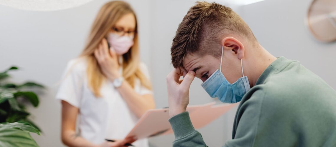 A worried patient discusses with a healthcare professional in a medical office setting.