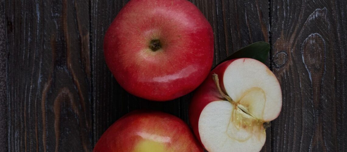 Top view of fresh red apples on a rustic wooden table.