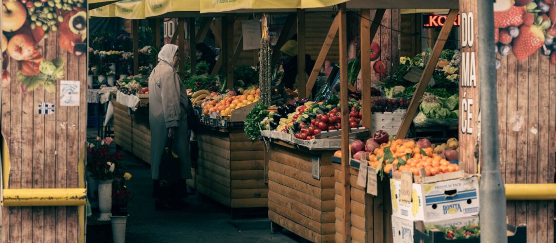 A bustling outdoor market with fresh fruits and vegetables on display.