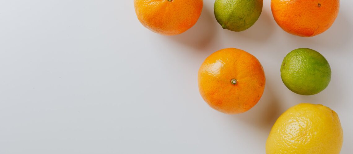 Vibrant and fresh assortment of citrus fruits including oranges, lemons, and limes on a white surface.