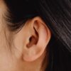Detailed close-up photo showcasing a human ear with dark hair.