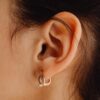 Detailed close-up of a woman's ear adorned with a stylish earring.