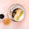 Delicious yogurt bowl topped with fresh kiwi, cashews, and mixed berries, perfect for a healthy breakfast.
