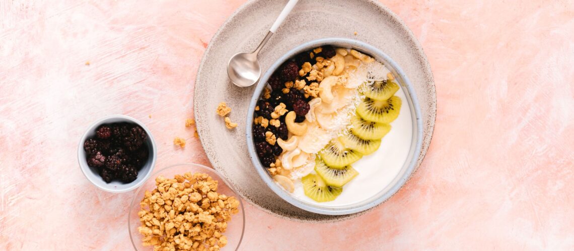 Delicious yogurt bowl topped with fresh kiwi, cashews, and mixed berries, perfect for a healthy breakfast.