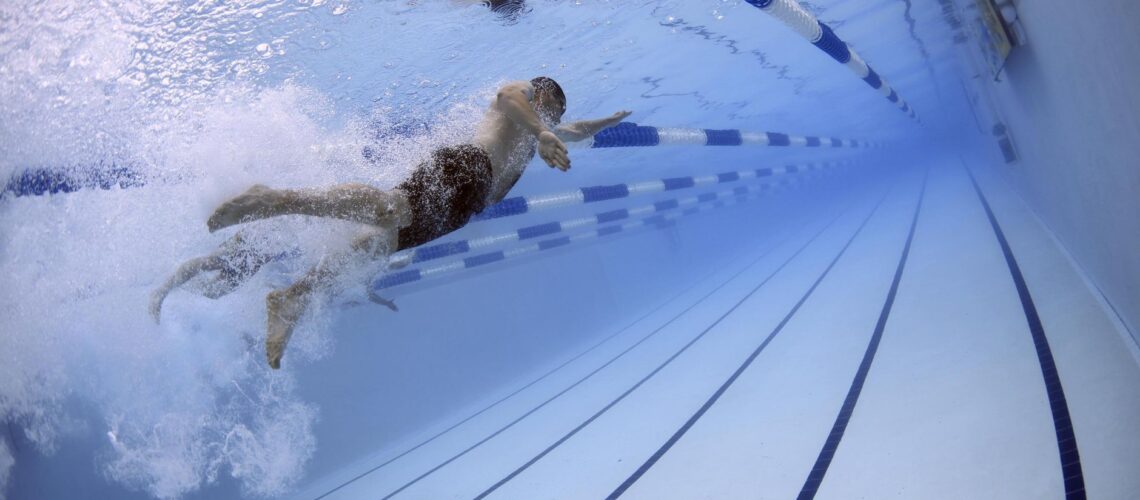 Dynamic image of swimmers in an underwater pool race showcasing freestyle techniques.