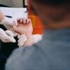 Healthcare professional checks man's pulse during medical examination.