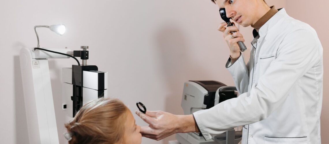A medical professional examining a child's vision using specialized equipment.