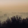 Atmospheric view of Almaty city skyline enveloped in fog and smog.