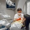 Dentist performing dental examination on female patient in modern clinic.