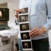 A person holding ultrasound images in a medical clinic, showcasing pregnancy monitoring.