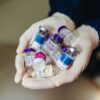 Close-up of gloved hands holding botulinum toxin vials in a laboratory, ideal for medical themes.