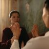 Two women practicing a calming hand exercise in a softly lit room, focusing on mindfulness and relaxation.