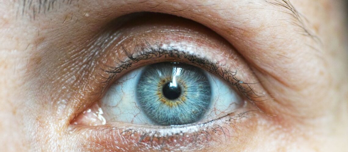Detailed close-up image of a woman's blue eye revealing intricate details.