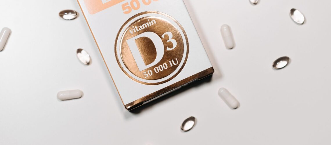 Flat lay of Vitamin D3 supplement box and capsules on a light background.
