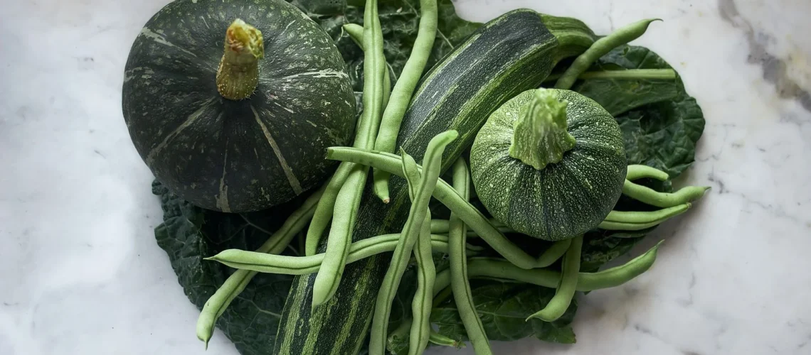 Étal coloré de légumes verts frais sur une surface en marbre, mettant en valeur une alimentation saine.