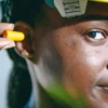 Gros plan d'une femme insérant un bouchon d'oreille, portant un équipement de protection.