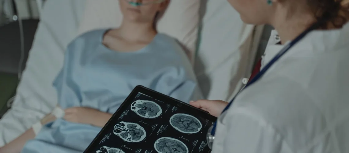 Médecin analysant des scanners cérébraux sur une tablette près d'un patient hospitalisé