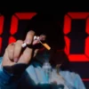 Une main tenant une cigarette cassée devant un minuteur numérique, soulignant l'urgence d'arrêter de fumer.